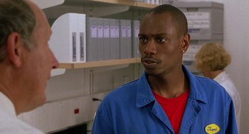 Movie still from “Half Baked” (1998), directed by Tamra Davis – A man wearing a blue shirt and a red shirt; Close Up shot, Over the shoulder angle