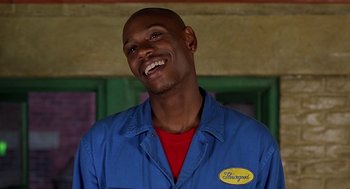Movie still from “Half Baked” (1998), directed by Tamra Davis – A man in a red shirt and blue jacket smiling for the camera; Close Up shot, Low angle