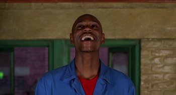 Movie still from “Half Baked” (1998), directed by Tamra Davis – A man in a red shirt and blue shirt laughing; Close Up shot, Low angle