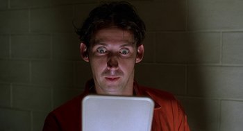 Movie still from “Half Baked” (1998), directed by Tamra Davis – A man looking at a tablet computer in a dark room; Close Up shot, Low angle