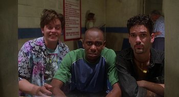 Movie still from “Half Baked” (1998), directed by Tamra Davis – A group of men sitting next to each other in a room; Medium shot, Low angle