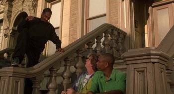 Movie still from “Half Baked” (1998), directed by Tamra Davis – Two men and a woman sitting on the steps of a building; Medium shot, Low angle