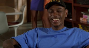 Movie still from “Half Baked” (1998), directed by Tamra Davis – A man in a blue shirt wearing a black hat; Close Up shot, High angle