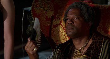 Movie still from “Half Baked” (1998), directed by Tamra Davis – A man holding an ornate red and gold umbrella; Close Up shot, Low angle
