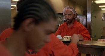 Movie still from “Half Baked” (1998), directed by Tamra Davis – A man in a red shirt is sitting in front of a plate of food; Medium shot, Over the shoulder angle