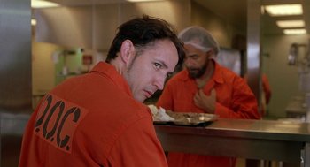 Movie still from “Half Baked” (1998), directed by Tamra Davis – A man in orange is sitting at a table; Close Up shot, Over the shoulder angle