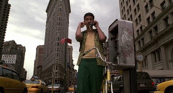 Movie still from “Half Baked” (1998), directed by Tamra Davis – A man standing next to a phone booth on the street; Wide shot, Low angle