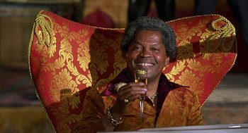 Movie still from “Half Baked” (1998), directed by Tamra Davis – An older man holding a glass of wine; Close Up shot, High angle