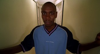 Movie still from “Half Baked” (1998), directed by Tamra Davis – A man standing in front of a wall with his hands on his hips; Medium shot, High angle