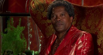Movie still from “Half Baked” (1998), directed by Tamra Davis – A man in a red robe is posing for a picture; Close Up shot, Low angle