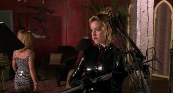 Movie still from “Half Baked” (1998), directed by Tamra Davis – A woman in a black outfit holding a rifle; Medium shot, Low angle