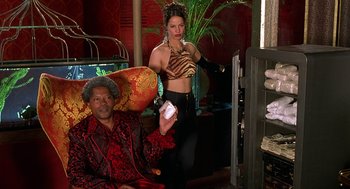 Movie still from “Half Baked” (1998), directed by Tamra Davis – A man and a woman are standing in a living room; Medium shot, Low angle