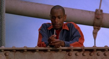 Movie still from “Half Baked” (1998), directed by Tamra Davis – A man leaning on a metal rail looking at the camera; Close Up shot, Low angle