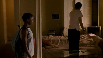 Movie still from “Half Nelson” (2006), directed by Ryan Fleck – Two people standing in a living room next to each other; Medium shot, Over the shoulder angle