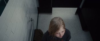 Movie still from “Halloween” (2007), directed by Rob Zombie – A young girl sitting on the floor of a bathroom; Close Up shot, Overhead angle