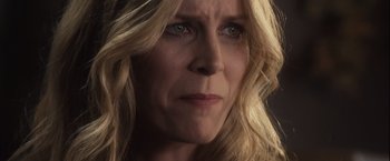 Movie still from “Halloween” (2007), directed by Rob Zombie – A woman's face in a dimly - lit room; Close Up shot, Over the shoulder angle