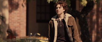 Movie still from “Halloween” (2007), directed by Rob Zombie – A young man wearing a brown jacket and a black shirt; Medium shot, Over the shoulder angle