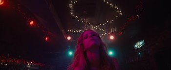 Movie still from “Halloween” (2007), directed by Rob Zombie – A woman is standing in a room with lights in the background; Medium shot, Low angle