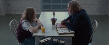 Movie still from “Halloween” (2007), directed by Rob Zombie – A man and a woman sitting at a table; Medium shot, Over the shoulder angle