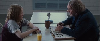 Movie still from “Halloween” (2007), directed by Rob Zombie – Two people sitting at a table having a conversation; Medium shot, Over the shoulder angle