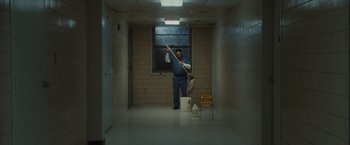 Movie still from “Halloween” (2007), directed by Rob Zombie – A man holding a broom in a hallway; Wide shot, Low angle