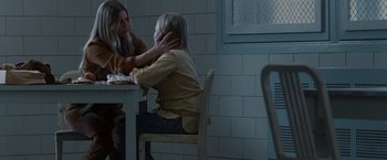 Movie still from “Halloween” (2007), directed by Rob Zombie – A woman sitting at a table next to another woman; Medium shot, Over the shoulder angle