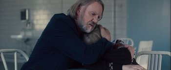 Movie still from “Halloween” (2007), directed by Rob Zombie – A man holding a child in his arms; Close Up shot, Over the shoulder angle