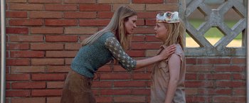 Movie still from “Halloween” (2007), directed by Rob Zombie – A woman is touching the face of another woman in front of a brick wall; Medium shot, Over the shoulder angle
