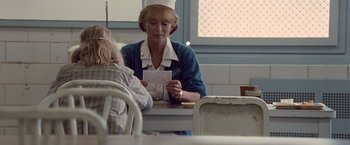 Movie still from “Halloween” (2007), directed by Rob Zombie – An older woman sitting at a table with a young child; Medium shot, Over the shoulder angle