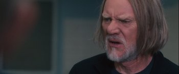 Movie still from “Halloween” (2007), directed by Rob Zombie – An older man with long hair and a beard; Close Up shot, Over the shoulder angle