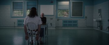 Movie still from “Halloween” (2007), directed by Rob Zombie – Two people sitting at a table in front of a window; Wide shot, Over the shoulder angle