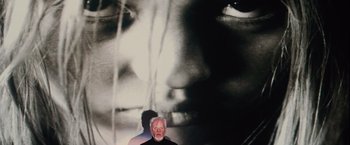 Movie still from “Halloween” (2007), directed by Rob Zombie – An older man standing in front of a large black and white photo; Extreme Close Up shot, Overhead angle