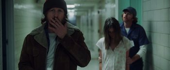 Movie still from “Halloween” (2007), directed by Rob Zombie – A man smoking a cigarette in front of a woman; Medium shot, Over the shoulder angle