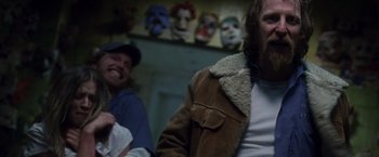 Movie still from “Halloween” (2007), directed by Rob Zombie – Two men are standing in front of a wall of masks; Medium shot, Over the shoulder angle