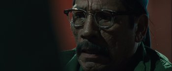 Movie still from “Halloween” (2007), directed by Rob Zombie – An older man with glasses and a mustache; Close Up shot, Over the shoulder angle