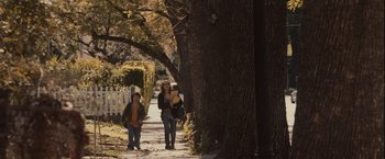 Movie still from “Halloween” (2007), directed by Rob Zombie – Two women walking down a tree lined sidewalk; Wide shot, Over the shoulder angle