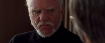 Movie still from “Halloween” (2007), directed by Rob Zombie – An older man with a white beard and a black shirt; Close Up shot, Over the shoulder angle