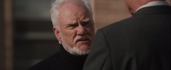 Movie still from “Halloween” (2007), directed by Rob Zombie – An older man with white hair and a goatee; Close Up shot, Over the shoulder angle