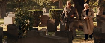 Movie still from “Halloween” (2007), directed by Rob Zombie – An older man walking through a cemetery holding papers; Wide shot, Over the shoulder angle