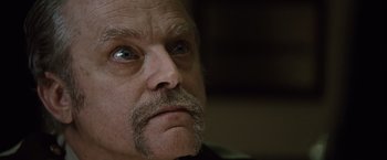 Movie still from “Halloween” (2007), directed by Rob Zombie – An older man with a mustache looking at the camera; Close Up shot, Low angle