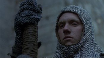Movie still from “Hamlet” (1990), directed by Franco Zeffirelli – A man wearing a chain mail hood and a chain mail scarf; Close Up shot, Low angle