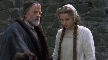 Movie still from “Hamlet” (1990), directed by Franco Zeffirelli – A man standing next to a young girl in front of a stone wall; Medium shot, Over the shoulder angle