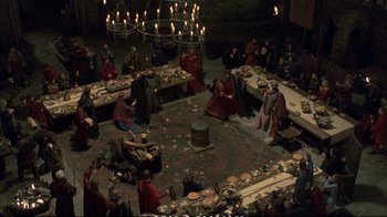 Movie still from “Hamlet” (1990), directed by Franco Zeffirelli – A group of people sitting around a dinner table; Extreme Wide shot, High angle
