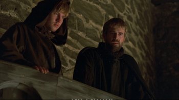 Movie still from “Hamlet” (1990), directed by Franco Zeffirelli – Two men in black jackets standing next to a stone wall; Medium shot, Low angle