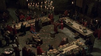 Movie still from “Hamlet” (1990), directed by Franco Zeffirelli – A group of people sitting around a dinner table; Extreme Wide shot, High angle