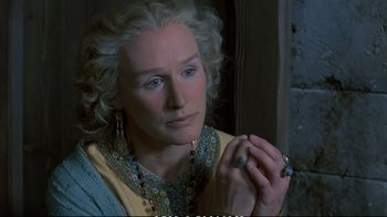 Movie still from “Hamlet” (1990), directed by Franco Zeffirelli – An older woman is holding a ring in her hand; Close Up shot, High angle