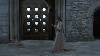 Movie still from “Hamlet” (1990), directed by Franco Zeffirelli – A woman in a long dress is looking at her phone; Wide shot, High angle