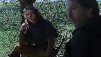 Movie still from “Hamlet” (1990), directed by Franco Zeffirelli – A man sitting next to another man on a tree branch; Medium shot, Low angle