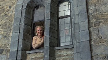 Movie still from “Hamlet” (1990), directed by Franco Zeffirelli – A woman standing at a window looking out of a window; Medium shot, Low angle