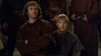 Movie still from “Hamlet” (1990), directed by Franco Zeffirelli – Two men in medieval garb sitting next to each other; Close Up shot, Low angle